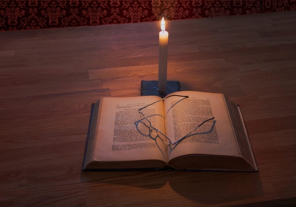 Vela encendida junto a un cuaderno abierto