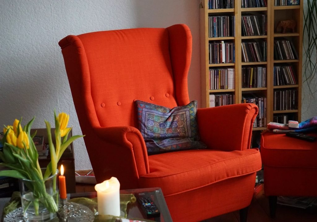 Sillón borgoña junto a una ventana luminosa